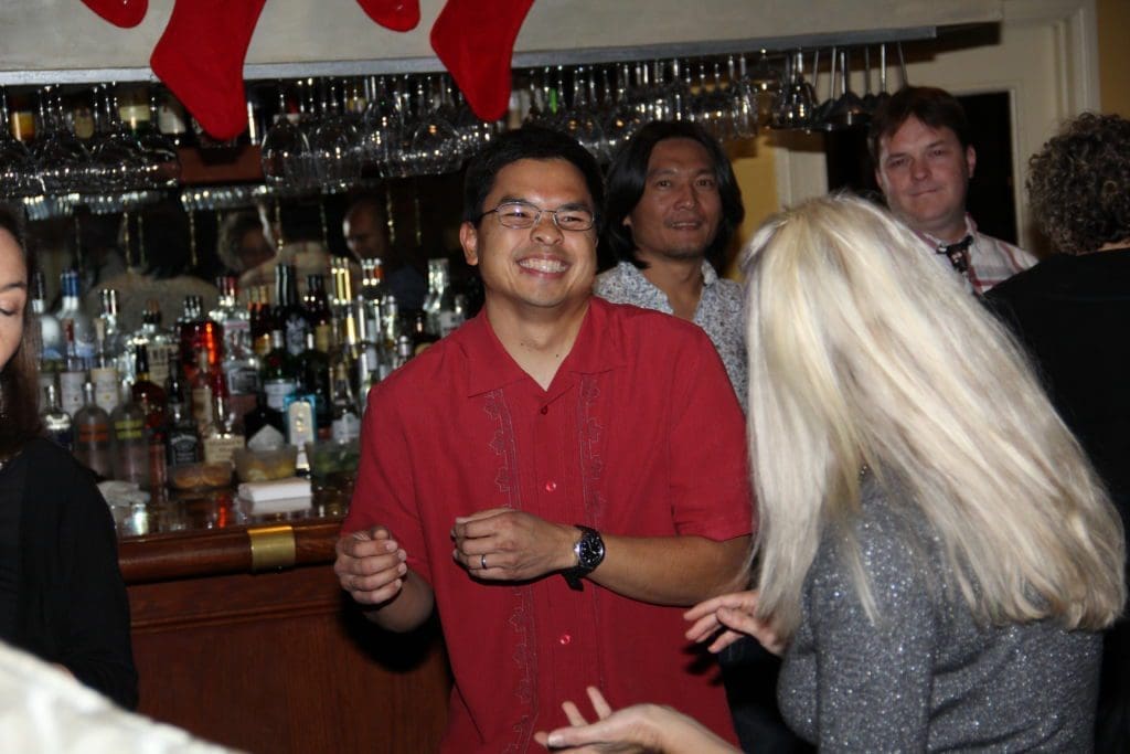 NOVO team members celebrating the holiday at a bar with Christmas stocking hanging overhead