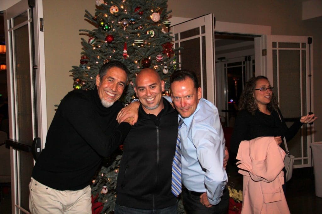 three engineers posing in front of a Christmas tree