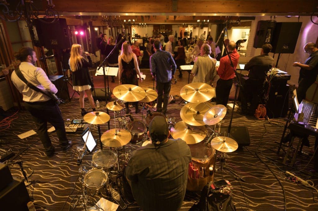 NOVO engineers playing in a rock band. Rearview shot from behind the drummer