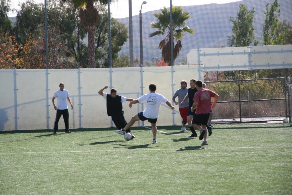 a man attempting to steal possession of a soccer ball from another player